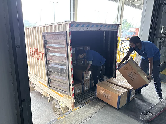 Mitarbeiter laden sorgfältig Kartons in einen LKW-Container ein, an einem Logistikzentrum von Jeena, was den reibungslosen Warentransport für SupplyX und GDP verdeutlicht.
