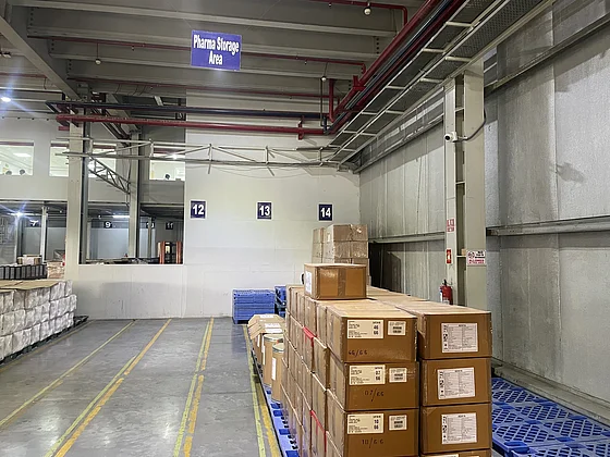  Ein ordentliches Lager mit gestapelten Kartons und einem Schild "Receiving", das die Lagerung von Pharmazeutika in der SupplyX-GDP Lieferkette bei Jeena zeigt.
